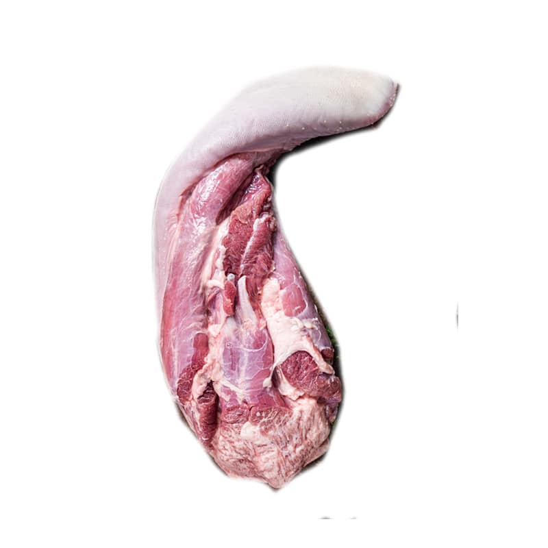 Raw beef tongue on kitchen table with herbs. Dark background. Top view.